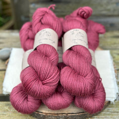 Five skeins of purpley red yarn