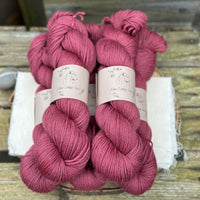 Five skeins of purpley red yarn