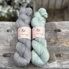 Two skeins of yarn - one grey and one pale green