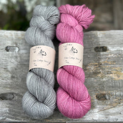 Two skeins of yarn - one grey, one pinky purple