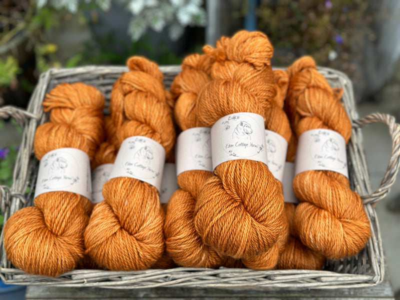 A basket of dark orange skeins of yarn