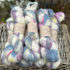 Multicoloured fluffy yarn on an upturned wicker basket. 
