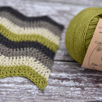 Green yarn alongside a crochet sample
