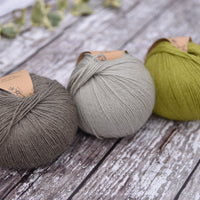 Three balls of yarn in green and greys