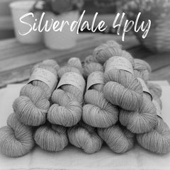 A black and white image of ten skeins of yarn with spakly filament visible around the skeins. "Silverdale 4ply" is in white text at the top of the image