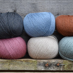 Six balls of Milburn 4ply in black, blue, beige, rust and pink