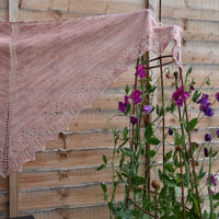 Buttermere shawl by Victoria Magnus hanging in front of a fence