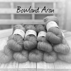 Black and white image of skeins of yarn with "Bowland Aran" overlaid in black text