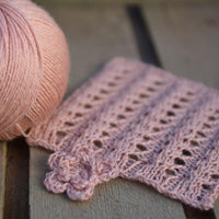 Peachy orange yarn alongside a knitted square