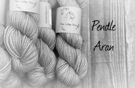 Black and white image of skeins of yarn with "Pendle Aran" overlaid in black text