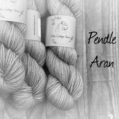 Black and white image of skeins of yarn with "Pendle Aran" overlaid in black text