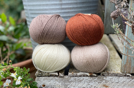 Four balls of Milburn. On the top row is a brown ball and a reddish brown ball. On the bottom row is a cream ball and a beige ball.