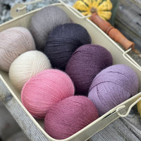 Eight balls of Milburn 4ply in shades of pink, grey and purple