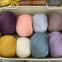 Eight balls of Milburn 4ply in shades of purple, blue and brown