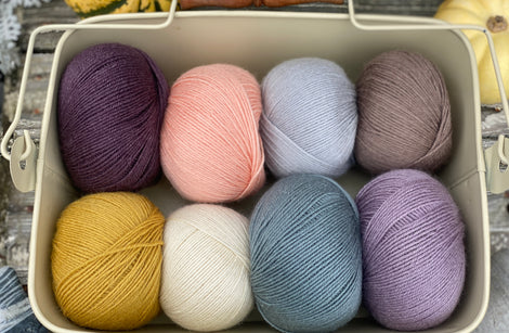 Eight balls of Milburn 4ply in shades of purple, blue and brown