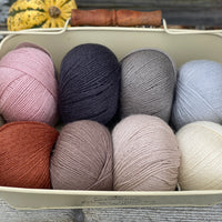 Eight balls of Milburn 4ply in shades of brown, grey and red