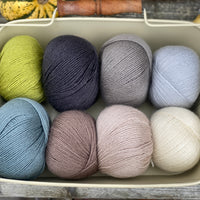 Eight balls of Milburn 4ply in shades of brown, grey and green