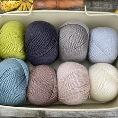 Eight balls of Milburn 4ply in shades of brown, grey and green