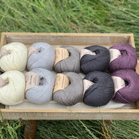 Balls of Milburn 4ply in shades of cream, grey and purple