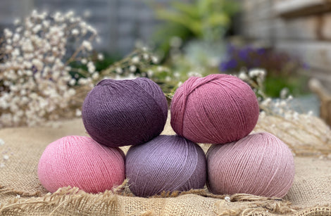 Five balls of Milburn 4ply in shades of pink and purple