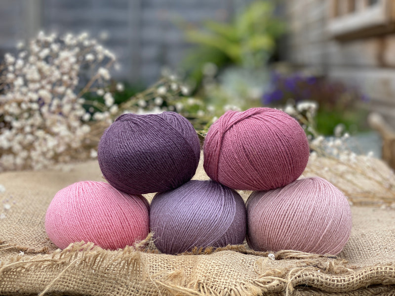Five balls of Milburn 4ply in shades of pink and purple