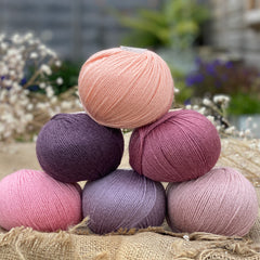Six balls of Milburn 4ply in shades or pink and purple