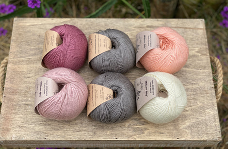 Six balls of yarn in grey and pinks