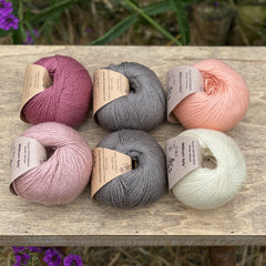 Six balls of yarn in grey and pinks