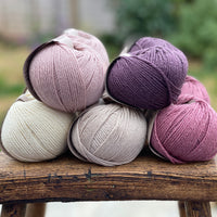10 balls of yarn in five colours, a fade of pink/purple