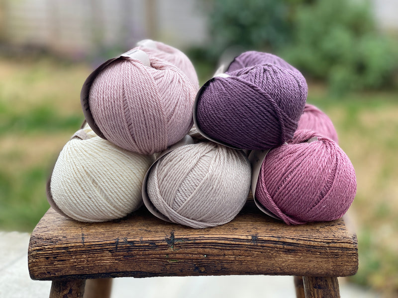10 balls of yarn in five colours, a fade of pink/purple