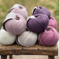 10 balls of yarn in five colours, a fade of pink/purple