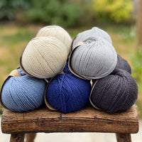 10 balls of yarn in five colours, a fade of blues