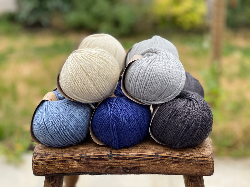 10 balls of yarn in five colours, a fade of blues