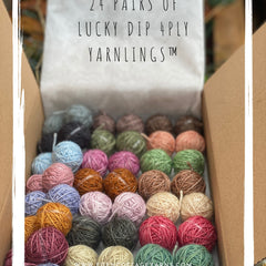 A box of 24 Yarnling pairs. Text at the top of the image is "24 pairs of Lucky Dip 4ply Yarnlings"