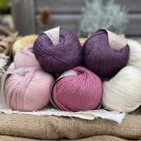 Eight balls of Milburn 4ply in shades of pink, purple and cream