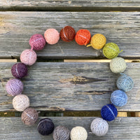 19 small balls of yarn arranged in a circle