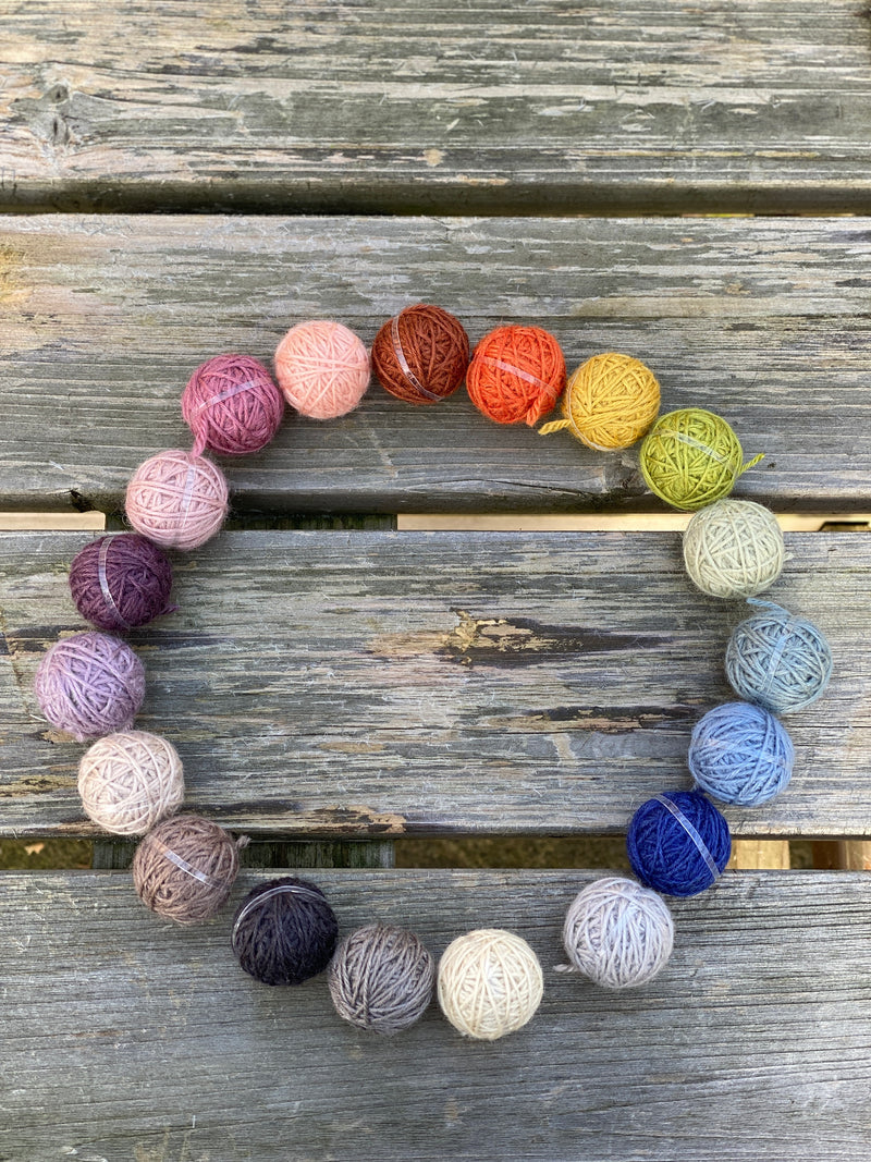 19 small balls of yarn arranged in a circle