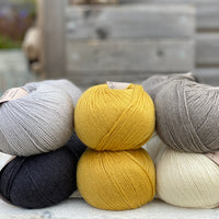 Ten balls of Milburn in shades of grey with a pop of yellow