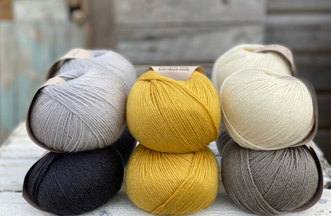 Ten balls of Milburn in shades of grey with a pop of yellow