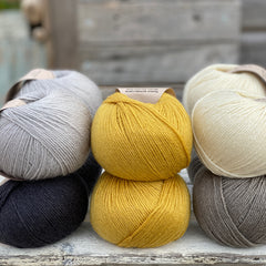 Ten balls of Milburn in shades of grey with a pop of yellow