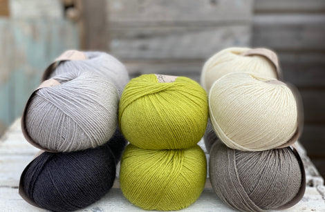 Ten balls of Milburn in shades of grey with a pop of green