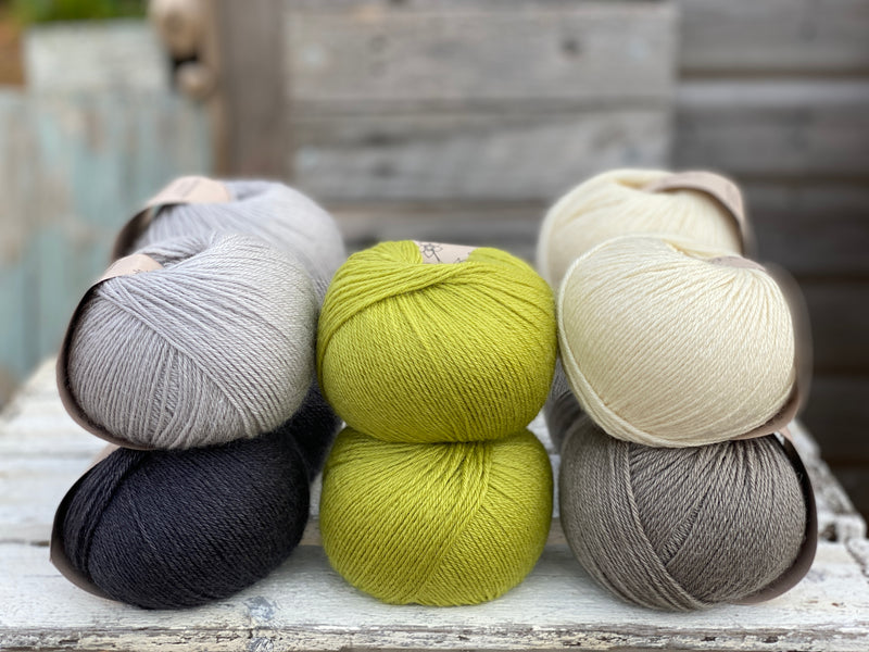 Ten balls of Milburn in shades of grey with a pop of green