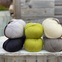 Ten balls of Milburn in shades of grey with a pop of green