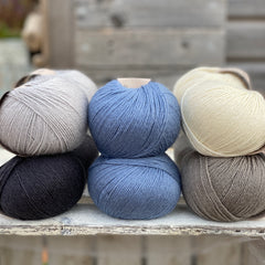 Ten balls of Milburn in shades of grey with a pop of blue