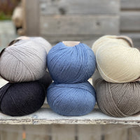 Ten balls of Milburn in shades of grey with a pop of blue