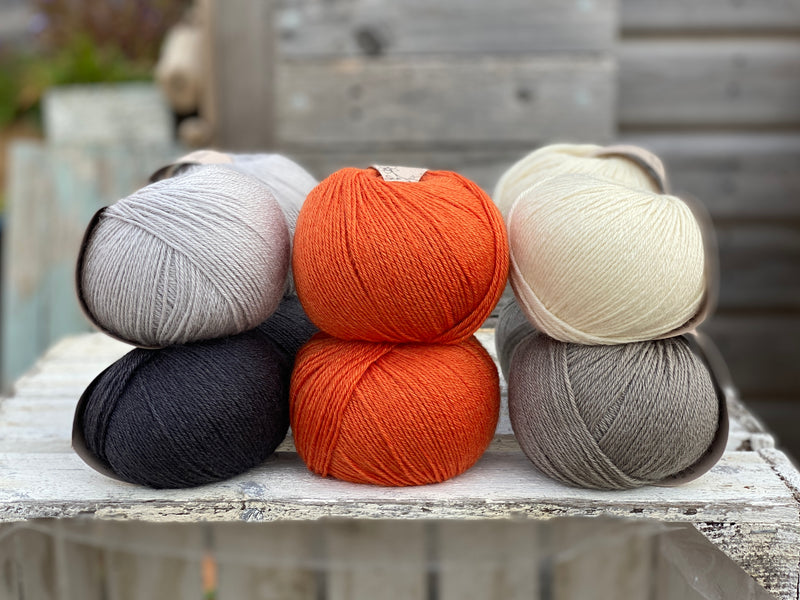 Ten balls of Milburn in shades of grey with a pop of orange