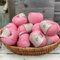 A basket filled with balls of pink yarn