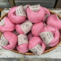 A basket filled with balls of pink yarn