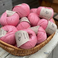 A basket filled with balls of pink yarn