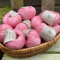 A basket filled with balls of pink yarn